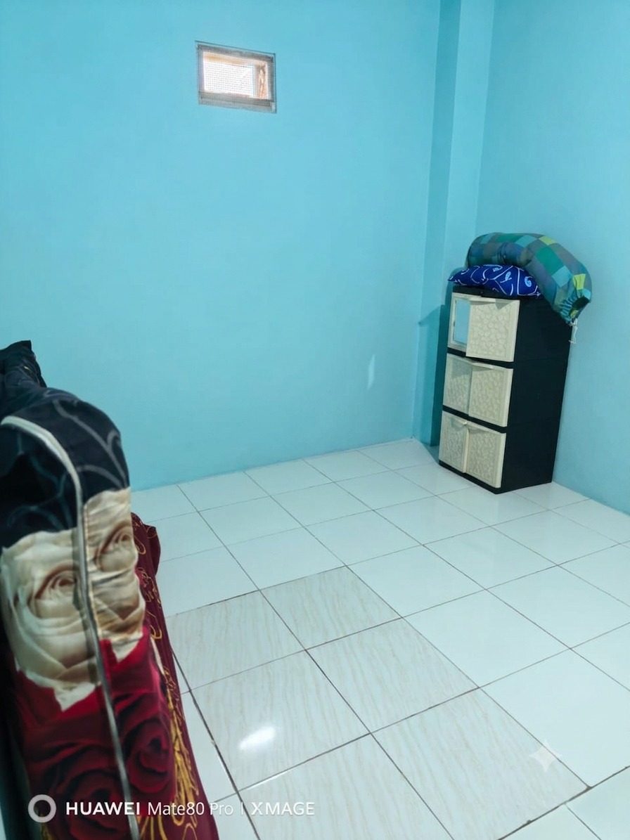 Kamar kost mandi luar di Kost Wisma Mataram Condongcatur dengan kasur, lemari plastik, dan lantai keramik putih